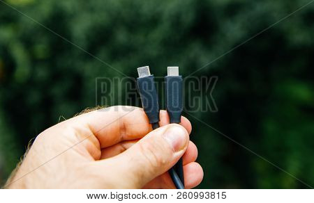 Man Holding New Black Usb-c Thunderbolt Cable For Ultra-fast Connection