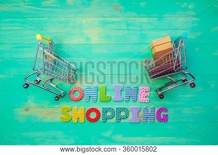Empty And Full Shopping Carts And Inscription Online Shopping On Green Wooden Background. Words Onli