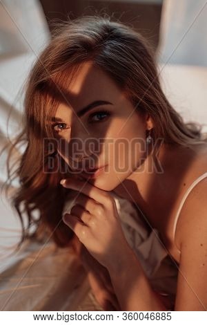 Fit And Sexy Woman With Brown Curly Hair Laying Among Bed Sheets With Star-shaped Confetti, Wearing 