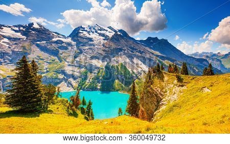 Magnificent view of the lake Oeschinensee in sunny day. Location place Swiss alps, Kandersteg district, Europe. Scenic image of unique place in world. Nature wallpapers. Discover the beauty of earth.