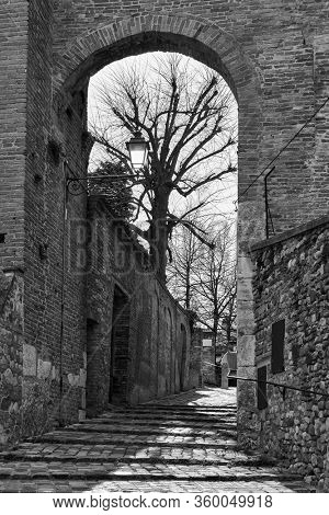 Gate and medieval street in Santarcangelo di Romagna town, Rimini Province, Italy. Black and white photography