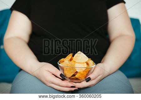 Overeating And Gluttony Concept. Mindless Snacking, Home Sedentary Lifestyle. Obese Woman Sitting On