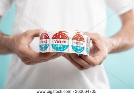 Democracy Elections In The Usa 2020. Man Holding I Vote Today Stickers Roll With American Flag, Blue
