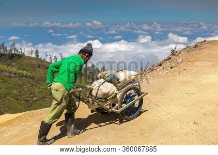 East Java, Indonesia - February 27, 2020: Miner Extracting Sulfur Inside The Crater Of Active Volcan