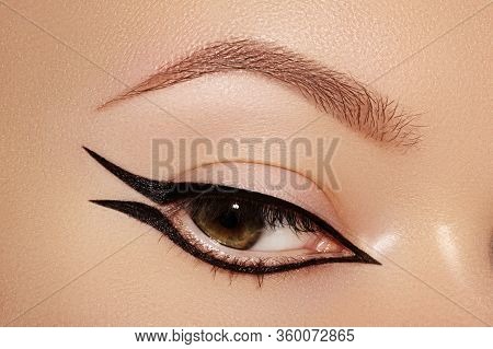 Beautiful Macro Of Female Eye With Fashion Black Eyeliner Makeup. Perfect Graphic Liner Shape. Cosme