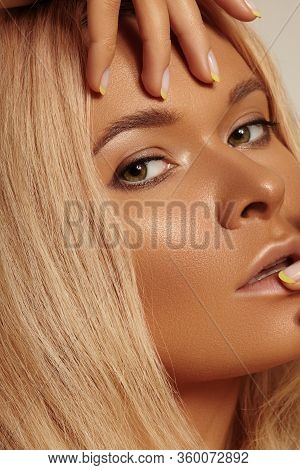 Beautiful Tanned Skin Woman. Sunburnt Girl Face With Natural Bronzed Make-up, Yellow Manicure. Sexy