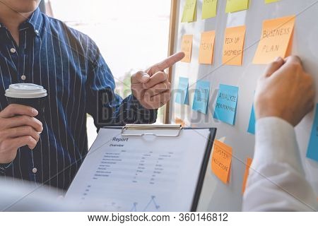 Young Business Workers Posting With Sticky Notes Stickers Reminders  Creative Brainstorming At Board