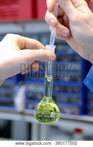 Conducting A Chemical Experiment In A Laboratory. Colored Flasks With Chemical Reagents. Many Glass 