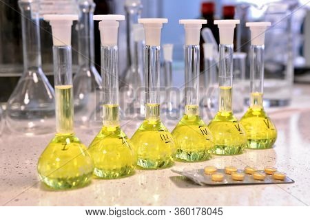 Conducting A Chemical Experiment In A Laboratory. Colored Flasks With Chemical Reagents. Many Glass 