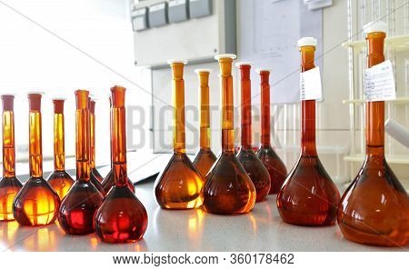 Conducting A Chemical Experiment In A Laboratory. Colored Flasks With Chemical Reagents. Many Glass 