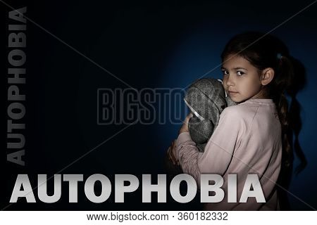 Sad Little Girl With Toy Near Blue Wall. Autophobia