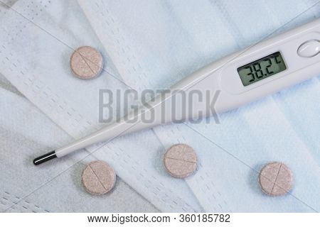 Electronic Thermometer And Pills With A Medical Mask