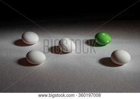 Wgite Eggs Placed Separatelly In Geometrical Pattern With One Green And Polka Dotted Among Them, Sho