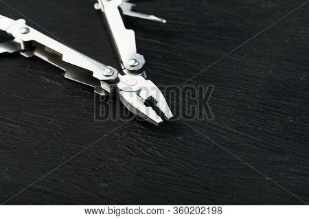 Multi-functional Tool On A Black Textural Background.