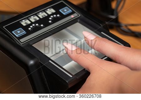 The Process Of Scanning Fingerprints During The Check At Border Crossing. Female Hand Puts Fingers T