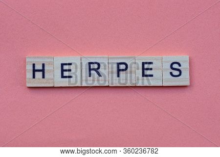 Word Herpes From Small Gray Wooden Letters Lies On A Red Background