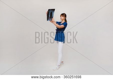 Female Brunette Doctor Looking At Tomography X-ray Film
