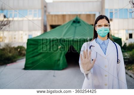 Coronavirus Er Doctor In Front Of Isolation Hospital.covid-19 Physician With Protective Glasses / Ma