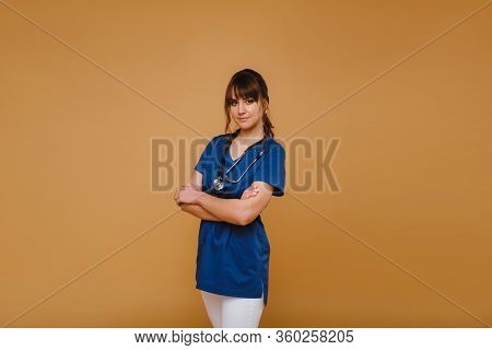 Cheerful Happy Doctor With Arms Crossed On A Brown Background