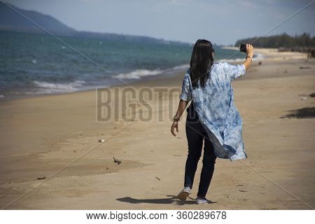 Traveler Thai Women Relax On The Beach And Portrait Posing For Take Photo With Wave Water Of Sea And