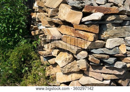 Stone Natural Flagstone Piled In A Pile. Natural Stone Flagstone, Laid In Uneven Rows. Background Of