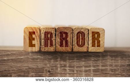 Macro Of The Word Error Formed By Wooden Blocks On A Wooden Table. Medical Mistake Concept. Mistakes