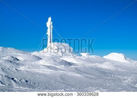 A Cabin With An Antenna Completely Covered By Snow And Ice On The Snowy Top Of 