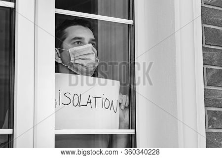 Man In A Medical Mask Holds A Tablet - Isolation. Isolation At Home For Self Quarantine. Home Quaran