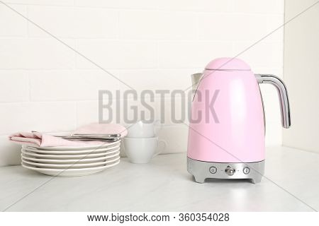 Modern Electric Kettle And Dishes On Counter In Kitchen