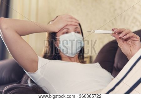Headache And Temperature Girl. Girl With A Thermometer In Hand Checks The Body Temperature. Sick You