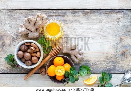 Healthy Products For Immunity Boosting On Wooden Background With Copy Space Top View. Lemon, Nuts, G