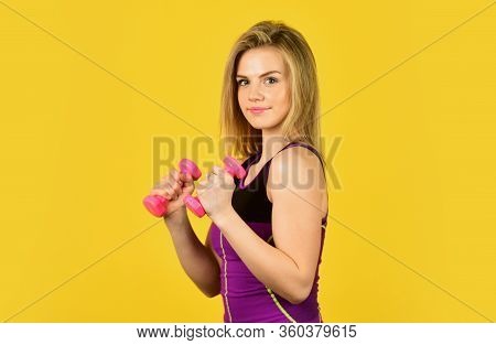 Muscular Woman In Training Pumping Up Muscles Of Hands. Girl Use Barbell Yellow Background. Slim Gir
