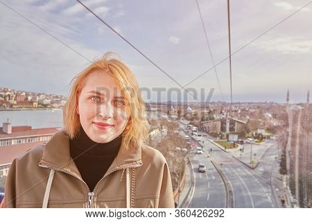 Young Pretty White Caucasian Woman In Casual Raincoat In The Cabin Of Cable Car During The Way To Th