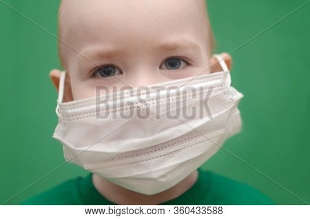 Boy In Face Mask In A Green T-shirt On A Green Background. Child Wear Facemask During Coronavirus An