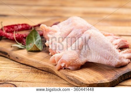 Raw Chicken Wings With Spices On A Wooden Cutting Board And On A Wooden Background. Fresh Chicken Wi