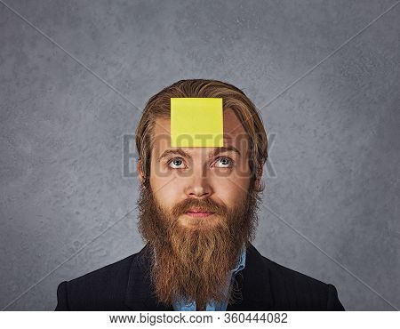 Bearded Smiling Business Man Looking Up To The Sticker Stick On His Head Forehead