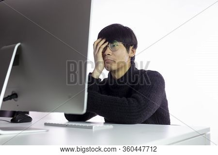 Chinese Overworked Men In Glasses Sitting In Office, Looks Exhausted, Tired Of Work. Hand Covers Fac