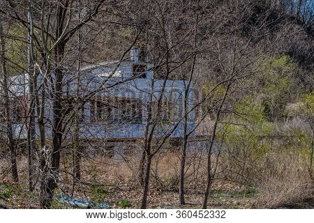 Hwanggan, South Korea; April 8, 2020: Abandoned Restaurant Building Behind Row Of Leafless Trees In 