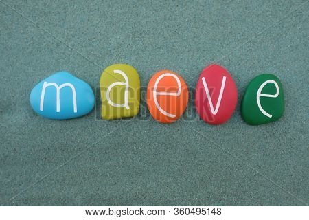 Maeve, Female Given Name Of Irish Origin Composed With Multi Colored Stone Letters Over Green Sand