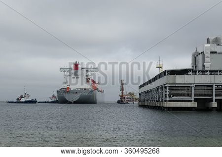 Lng Terminal And Gas Tanker - A Large Ship Maneuvers Into The Unloading Quay