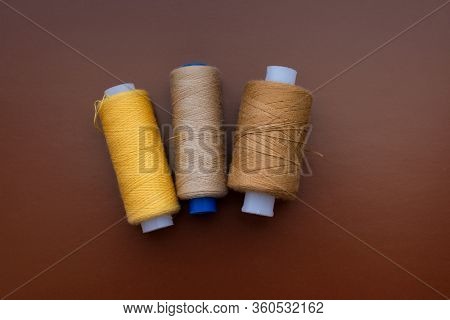 Babin Sewing Thread On A Brown Isolated Background, Top View
