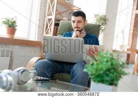 Young Focused Man Studying At Home During Online Courses Or Free Information By Hisself. Becomes Pro