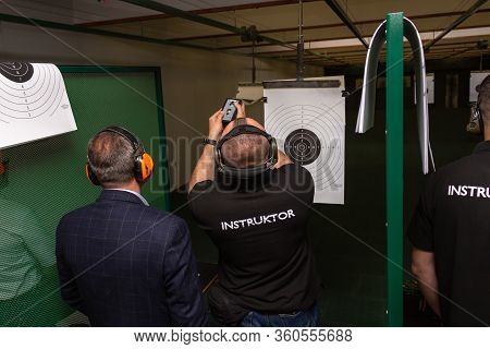 Shooting In The Dash Of Short-barreled Weapons. The Instructor In Special Ballistic Headphones Attac