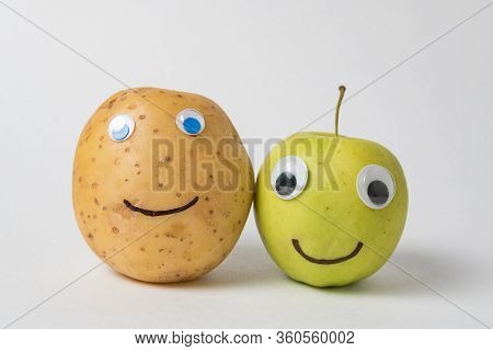 Raw Potato And Apple With Googly Eyes And Drawn Smile. Food With Funny Face.