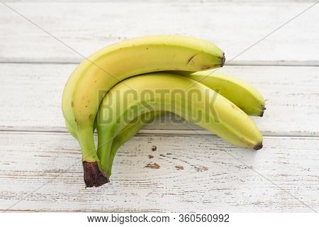 Bunch Of Green Bananas On White Wooden Background. Fruit Close-up