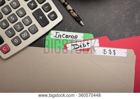 Flat Lay Background Office Bookkeeping File Folders With Dollor Signs Debt And Income Written On Tab