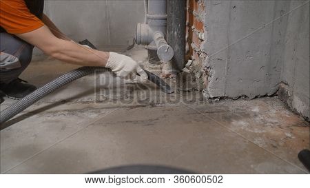 Worker Vacuuming Concrete Floors. Preparing The Floor For Waterproofing. Construction Cleaning With 