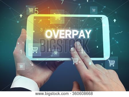 Close-up of a hand holding tablet with OVERPAY inscription, online shopping concept
