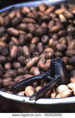 Cracker For Nuts And Pecans. Harvest Nuts On The Counter Of The Turkish Market. Tool For Cleaning Nu