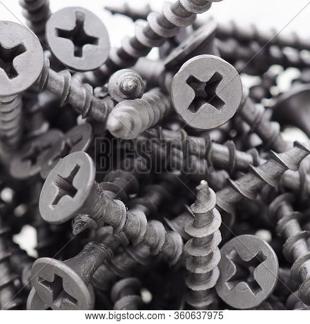 A Lot Of Black Big Screws Lie In A Pile On A White Background. Close-up. Hardware, Fasteners, Ironwa